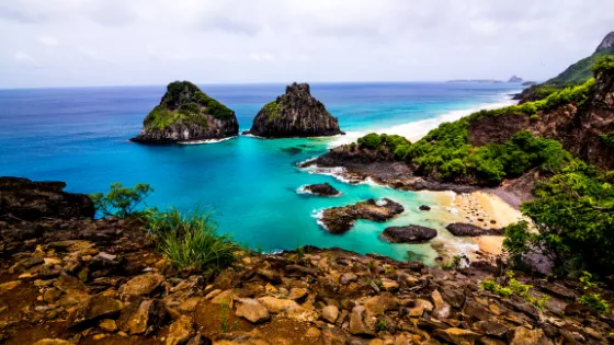 Vista panorámica de la Bahía do Sancho en Fernando de Noronha, Brasil, con aguas turquesas y formaciones rocosas. Viajes a Brasil, playas exóticas y turismo de naturaleza
