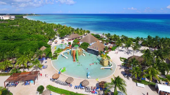 Resort familiar con parque acuático frente a la playa en la Riviera Maya, México. Viajes a la playa, vacaciones en familia y turismo en el Caribe